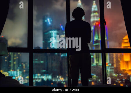 Man schaut aus dem Fenster in der Nacht Stadt Stockfoto