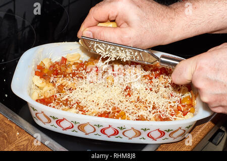 Kasserolle mit Ratatouille füllen, bestehend aus Tomaten, Zwiebeln, Paprika, Nudeln, Knoblauch und Käse. Stockfoto