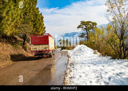 Landschaftlich reizvolle Straße durch das Tal von banikhet Dalhousie Himachal Pradesh mit Schnee Berge und Bäume abgedeckt. Bergauf scenic road winter Reisen c Stockfoto