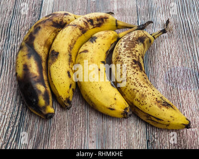 Reife Bananen, vier auf einem Tisch Stockfoto