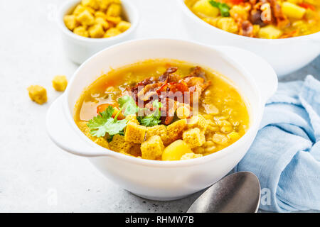 Split Erbsensuppe mit geräuchertem Speck und Cracker in eine weiße Platte. Stockfoto