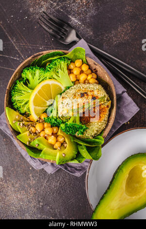 Veganes Mittagessen in einer Kokosnuss Schale: grün Burger mit Salat und Kichererbsen. Gesunde vegane Ernährung Konzept. Stockfoto