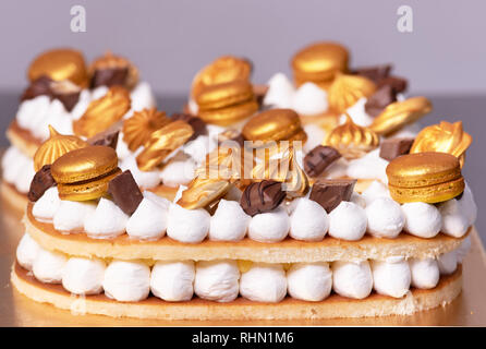 Köstliche Torte mit goldenen Süßigkeiten eingerichtet. Stockfoto