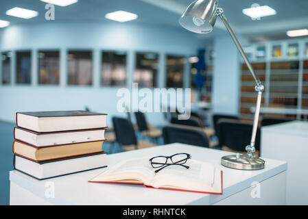 Stapel von Büchern und Gläser auf dem Tisch in der Universitätsbibliothek, niemand. Wissen, Bildung Konzept Stockfoto