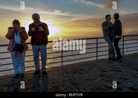 Zwei Paare, ein junges Paar und ein Paar mittleren Alters, an der Cristo Rei Sicht bei Sonnenuntergang, Garajau, Madeira Stockfoto