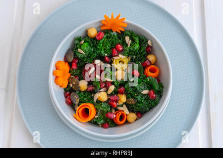 Schüssel mit kalettes (ein Kreuz zwischen Rosenkohl und Grünkohl), Kichererbsen, bunte Karotten, Granatapfel Samen und verschiedenen Samen Stockfoto