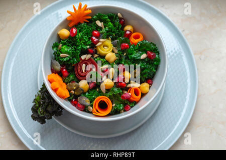 Gesunde Ernährung - Schüssel mit kalettes (ein Kreuz zwischen Rosenkohl und Grünkohl), Kichererbsen, bunte Karotten, Granatapfel Samen und Saatgut Stockfoto