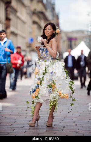 Ein Modell, das sich auf die Buchanan Street, Glasgow trägt ein Hochzeitskleid aus Blumen gemacht eine bevorstehende Hochzeit fayre zu fördern. Lenny Warren/Warren Medien07860 8. Stockfoto