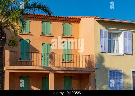 Farben der Provence, Frankreich, Sommer in der kleinen Stadt am Mittelmeer, bunten Fassaden und Fenster und Palmen. Stockfoto