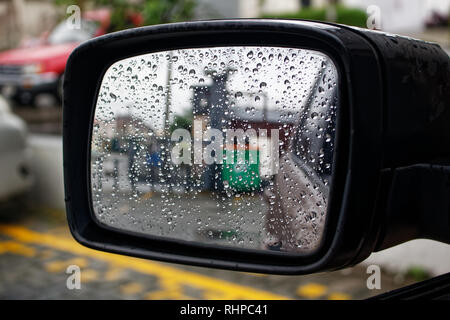 Wassertropfen auf einem Auto Spiegel, Reflexion auf Glas mit Regentropfen Stockfoto