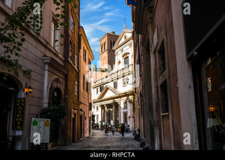 Touristen vorbei an Geschäften, einem schattigen Gasse in Richtung Saint Eustace Kirche mit dem Weißen Hirsch Skulptur auf dem Dach in Rom, Italien Stockfoto