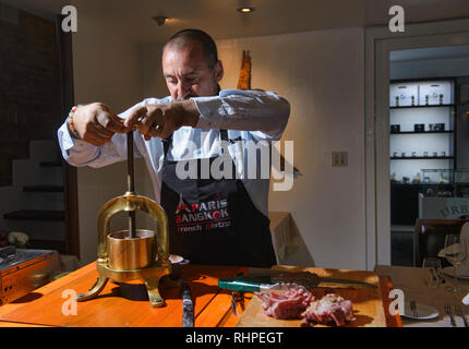 Französische Küchenchef Vorbereitung gedrückt Ente, Bangkok, Thailand Stockfoto