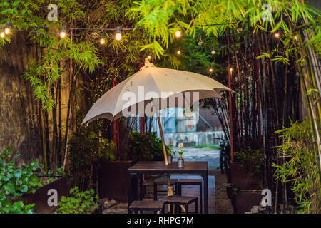 A Street Cafe mit einem Regenschirm und Leuchten Stockfoto