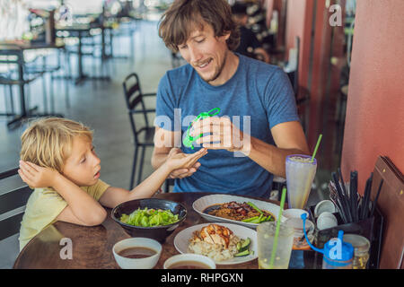 Vater und Sohn mit Waschen Handdesinfektionsmittel Gel vor dem Essen in einem Cafe Stockfoto