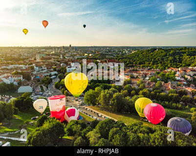 VILNIUS, LITAUEN - 15. AUGUST 2018: Bunte Heißluftballons, die in der Altstadt von Vilnius City an sonnigen Sommerabend. Viele Leute watchin Stockfoto