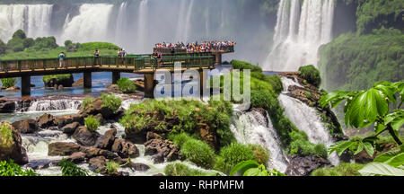 Touristen die Wasserfälle auf der Plattform in Iguazu National Park, Argentinien Stockfoto
