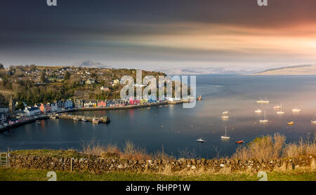 Schönen Sonnenaufgang über Tobermory Bay auf der Isle of Mull. Schottland Festland highland Gipfeln im Hintergrund. Stockfoto