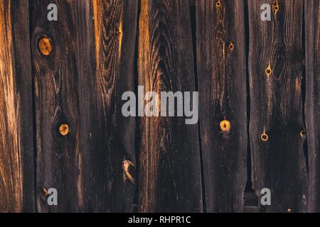 Mehrere alte Bretter, die gemeinsam getroffen werden, haben eine sehr dunkle Schatten. Auf den Brettern können Sie deutlich sehen, die Textur der Baum mit orange Flecken auf der Stockfoto