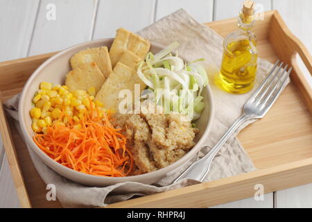 Buddha Schüssel mit Quinoa, gebratenem Tofu, Chicorée, Möhren, Mais, und Olivenöl Stockfoto