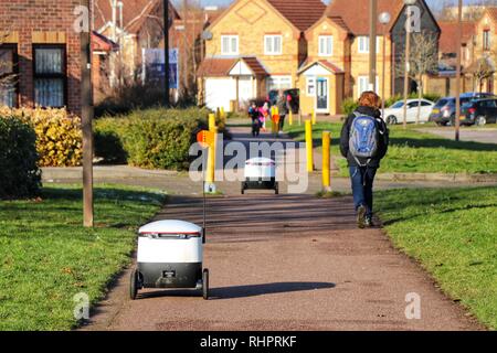 Fußgänger gehen Sie über Ihren Alltag als Starship autonomen Technologien Roboter routine Lebensmittellieferung rund um Milton Keynes. Stockfoto
