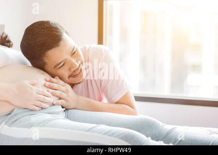 Asiatische schwangere Frau mit Mann. Mutter Tag und Internationalen Tag der Frau. Mama und Kind. Stockfoto