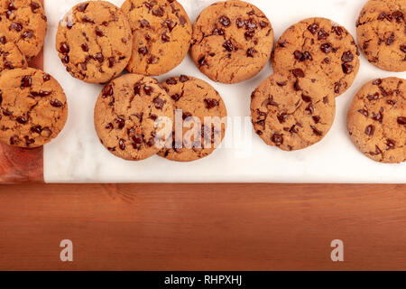 Ein Foto des frisch gebackenen Golden Brown Chocolate Chip Cookies, Schuß von der Oberseite in einem dunklen Holzmöbeln im Landhausstil Hintergrund mit Kopie Raum Stockfoto