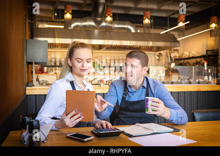 Kleine Familie Restaurant Besitzer Berechnung Rechnungen und profitieren Sie von kleinen Unternehmen mit digitalen Tablet Stockfoto