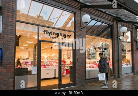 Einkäufer, die in Flying Tiger Copenhagen Shop Window York North Yorkshire England Großbritannien GB Großbritannien suchen Stockfoto
