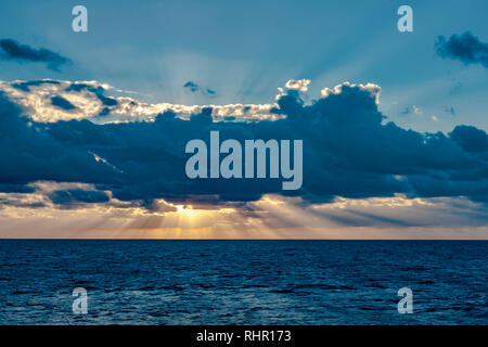 Sonnenstrahlen aus hinter Wolken, als die Sonne. Stockfoto