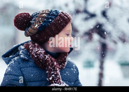 Seitenansicht eines Jungen im Winter Kleidung stehen im Schnee Stockfoto