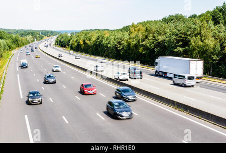 Schwere, aber flüssiger der Verkehr auf der Autobahn A10 in Frankreich in Richtung Paris an einem heißen Sommertag mit Autos, Lieferwagen, Anhänger und Auflieger. Stockfoto