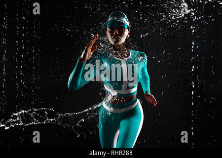 Eine starke sportlich, Frau sprinter, die auf schwarzen Hintergrund mit Spritzwasser tragen in den mint Farbe Sportbekleidung, Fitness und Sport Motivation. R Stockfoto