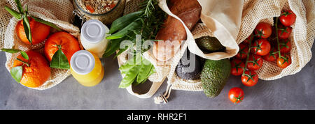 Satz von frischen biologischen Lebensmittel in Stoff umweltfreundlichen wiederverwendbaren Taschen, gesehen von oben auf grauem Hintergrund. Umwelt shopping banner Konzept Stockfoto