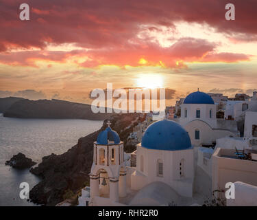 Das Dorf Oia mit Kirchen gegen Sonnenuntergang auf der Insel Santorin in Griechenland Stockfoto