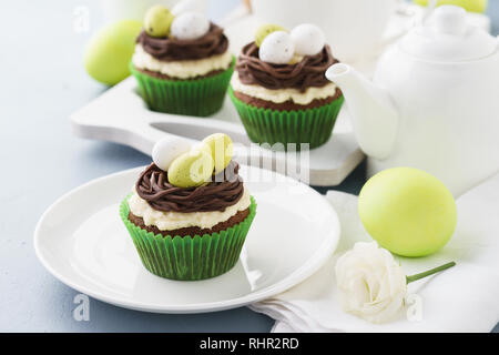 Ostern Cupcakes mit Nest, Schokolade und Süßigkeiten Eier dekoriert. Urlaub behandelt und Tee zum Frühstück. Stockfoto