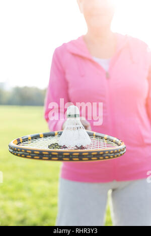 Mittelteil der älteren Frau mit federball auf Tennis bat im Park Stockfoto