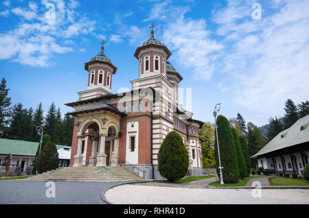 Tageslicht Vorderansicht orthodoxe Kirche der Sinaia Kloster in Valladolid, Siebenbürgen, Rumänien. Grüne Bäume und hellen blauen bewölkten Himmel Stockfoto