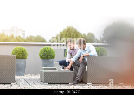 Unternehmer mit Laptop im Büro Terrasse sitzen Stockfoto