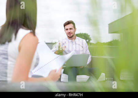 Kollegen diskutieren über Dokumente im Büro Terrasse Stockfoto