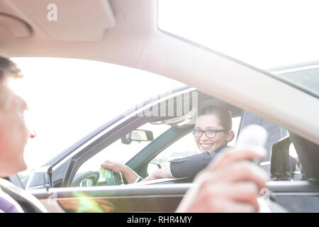 Lächelnd Executive und Geschäftsfrau Sprechen während der Sitzung in Autos Stockfoto