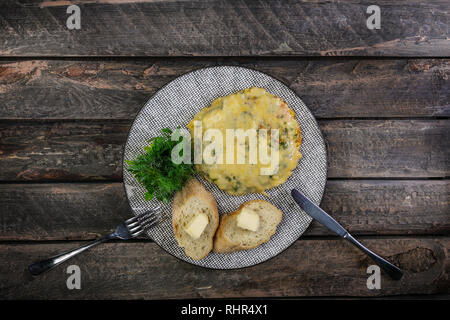 Omelett mit Tomaten, Zucchini und Pilzen von Besteck serviert. Omelette Frühstück. Gesundes Essen. Ansicht von oben. Stockfoto
