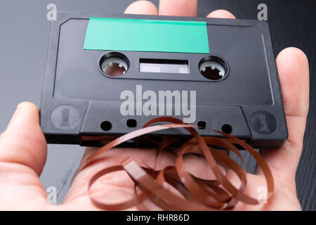 Audio Kassette mit Platz für Text Eintrag auf der Handfläche. Kassette ohne Beschreibung. Der dunkle Hintergrund. Stockfoto