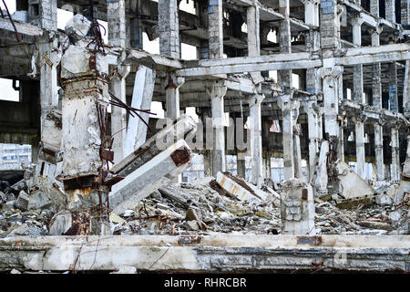 Bleibt der zerstörten Industrie Gebäude. Das Skelett eines großen Gebäudes an Betonbindern, der Vordergrund unter den Trümmern Stockfoto