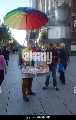 Einem Straßenhändler mit einem tragbaren Grill verkauft deutsche Bratwurst Wurst auf der Zeil in Frankfurt am Main. Stockfoto