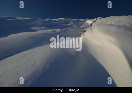 Wind treibt und Muster in den Schnee auf der Seite des Hügels Beinn Tharsuinn geblasen, in den schottischen Highlands, Großbritannien Stockfoto