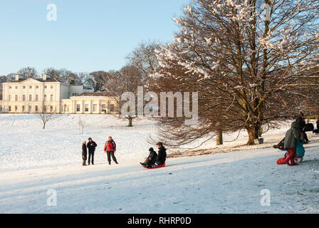 An einem verschneiten Wintertag Familien Schlitten hängen vor Kenwood House, London, UK. Stockfoto