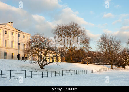 Kenwood House mit warmen Nachmittag Licht an einem verschneiten Wintertag, mit ein paar Leute in der Ferne. Stockfoto