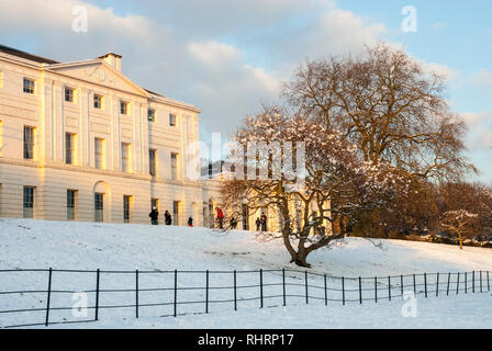 Kenwood House mit warmen Nachmittag Licht an einem verschneiten Wintertag, mit ein paar Leute in der Ferne. Stockfoto