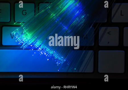 Bunte Glasfaser leuchten auf der Tastatur. High speed Internet Konzept. Datenübertragung Optic Fiber Kabel. Bündel viele optische Fasern, glühende di Stockfoto