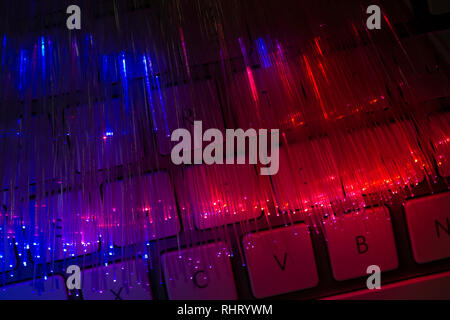 Bunte Glasfaser leuchten auf der Tastatur. High speed Internet Konzept. Datenübertragung Optic Fiber Kabel. Bündel viele optische Fasern, glühende di Stockfoto
